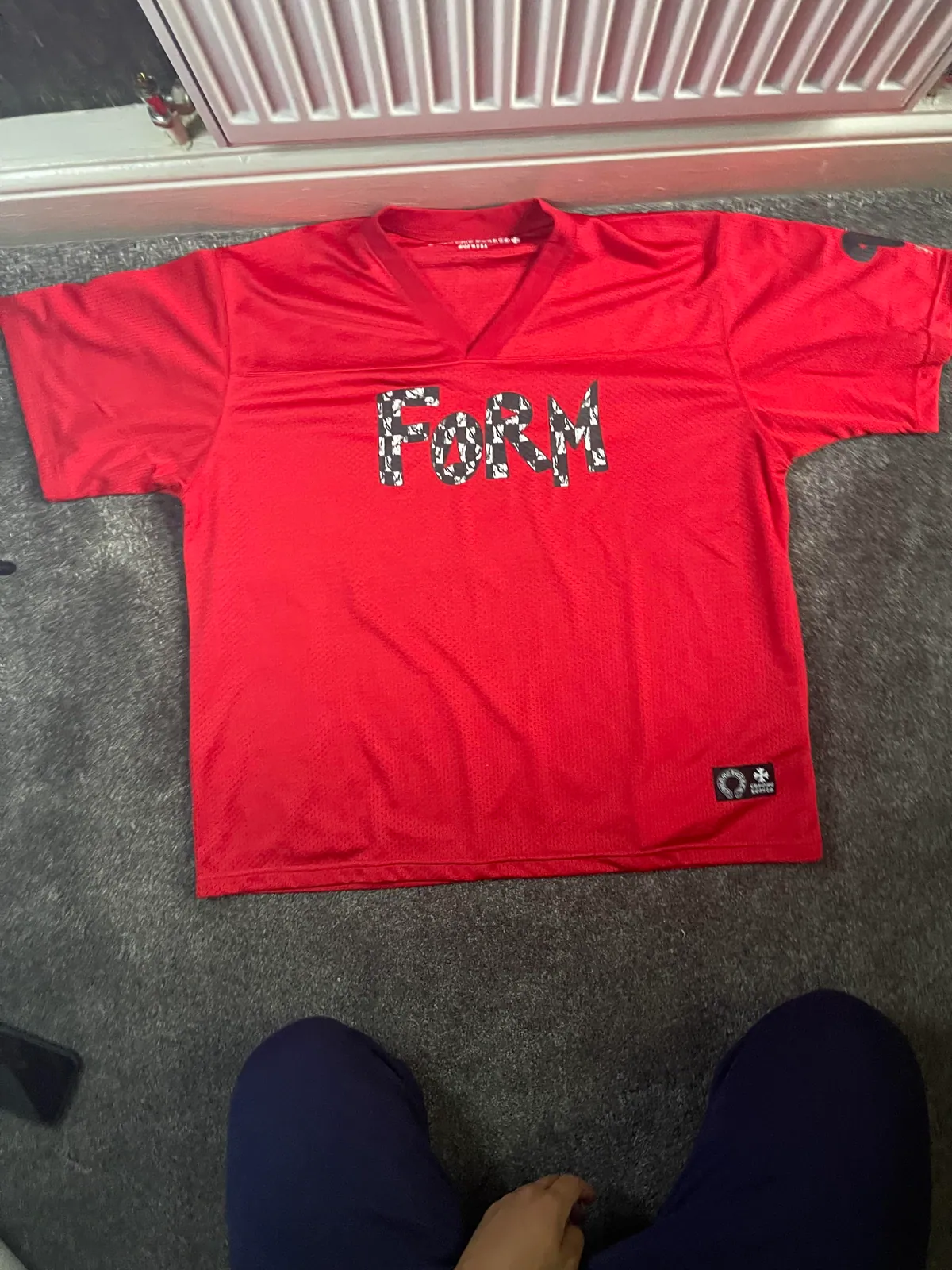 Red mesh V-neck jersey with a large graphic on the front