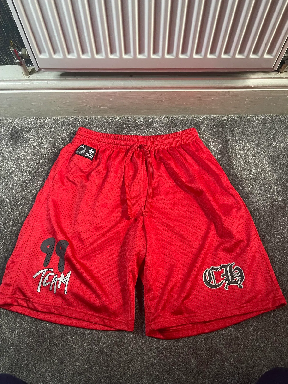 Red mesh drawstring shorts with printed graphics