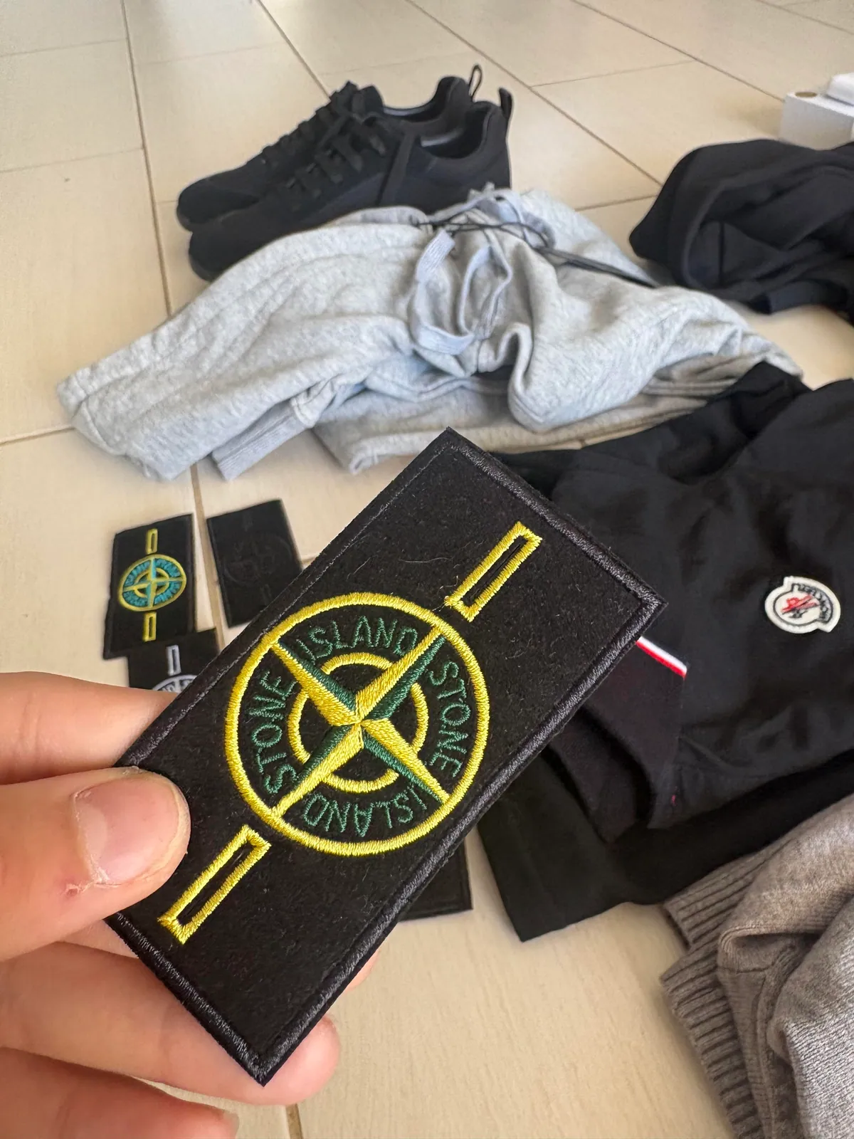 Close-up of a yellow compass-style badge held between fingers