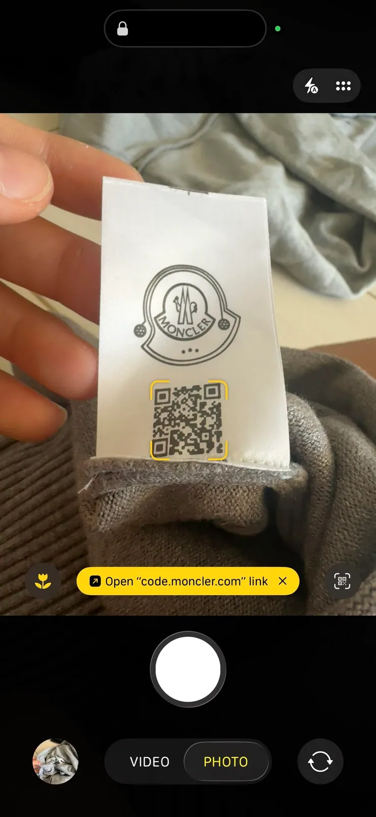 Phone camera pointed at a QR code on a clothing label