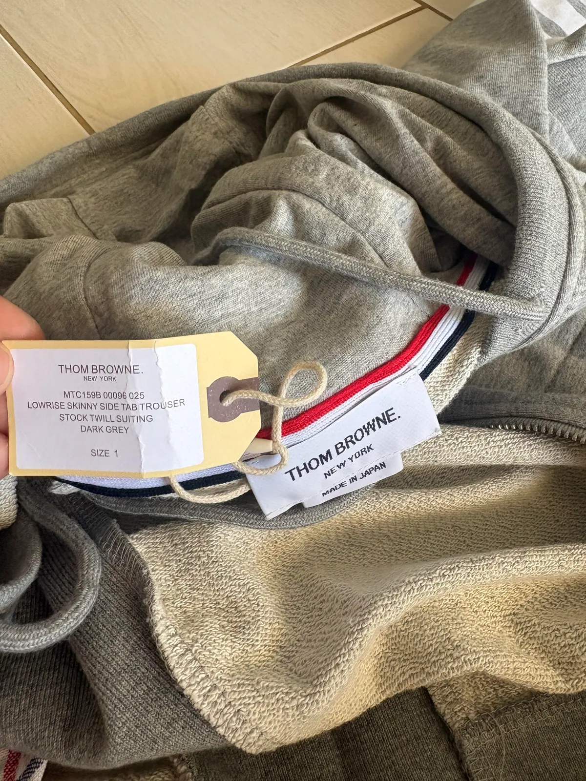 Fabric label and hanging tag inside a gray garment