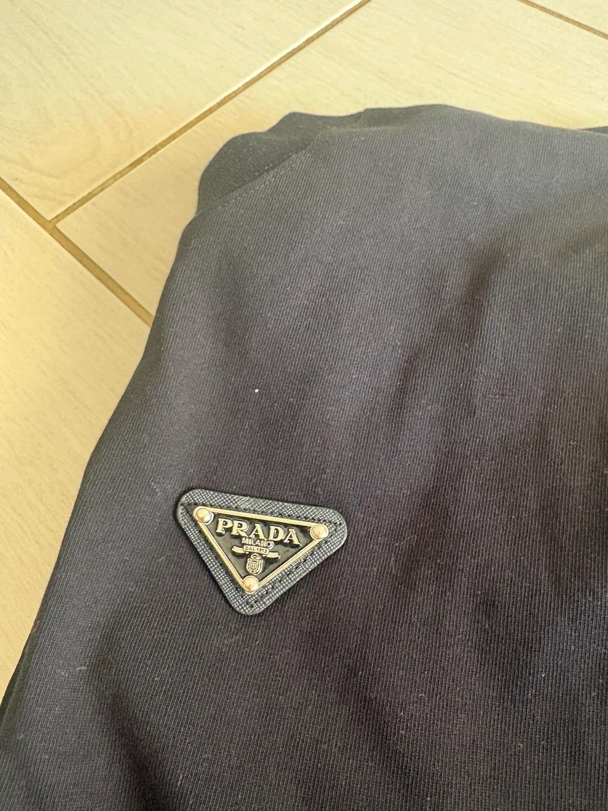 Triangular logo-style patch on a black T-shirt