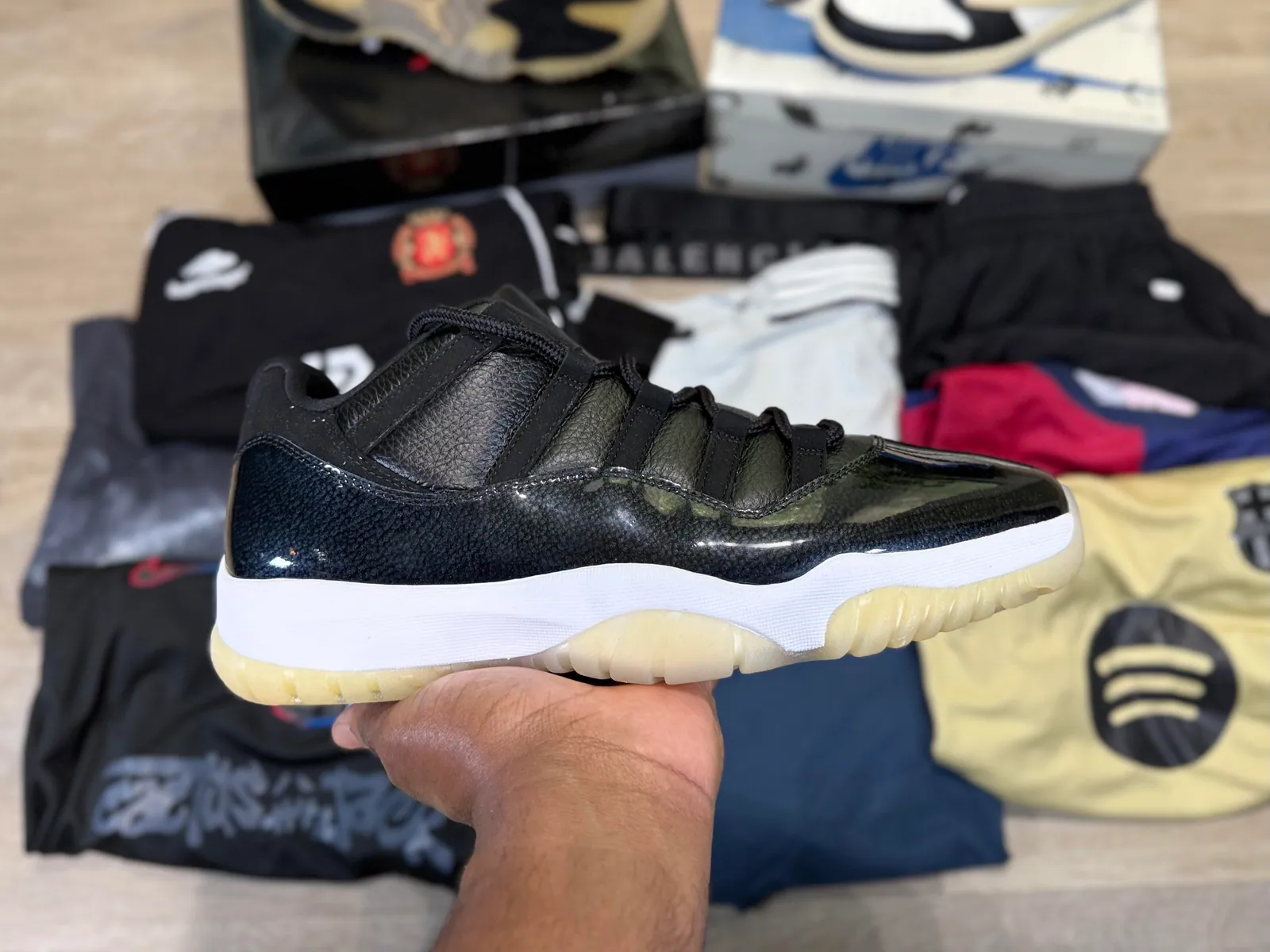 Black low-top sneaker held in front of the haul