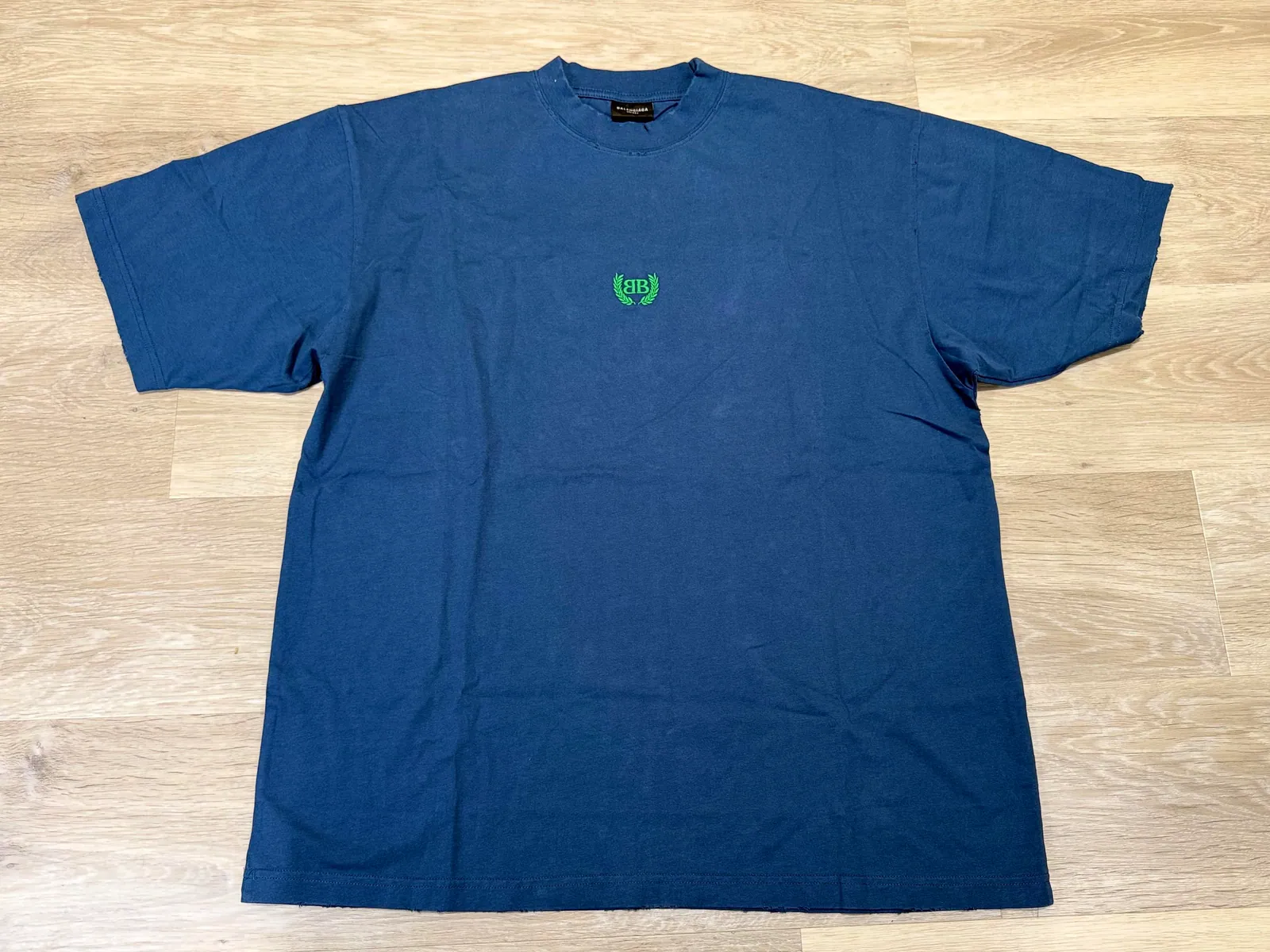 Blue T-shirt with a small green chest emblem