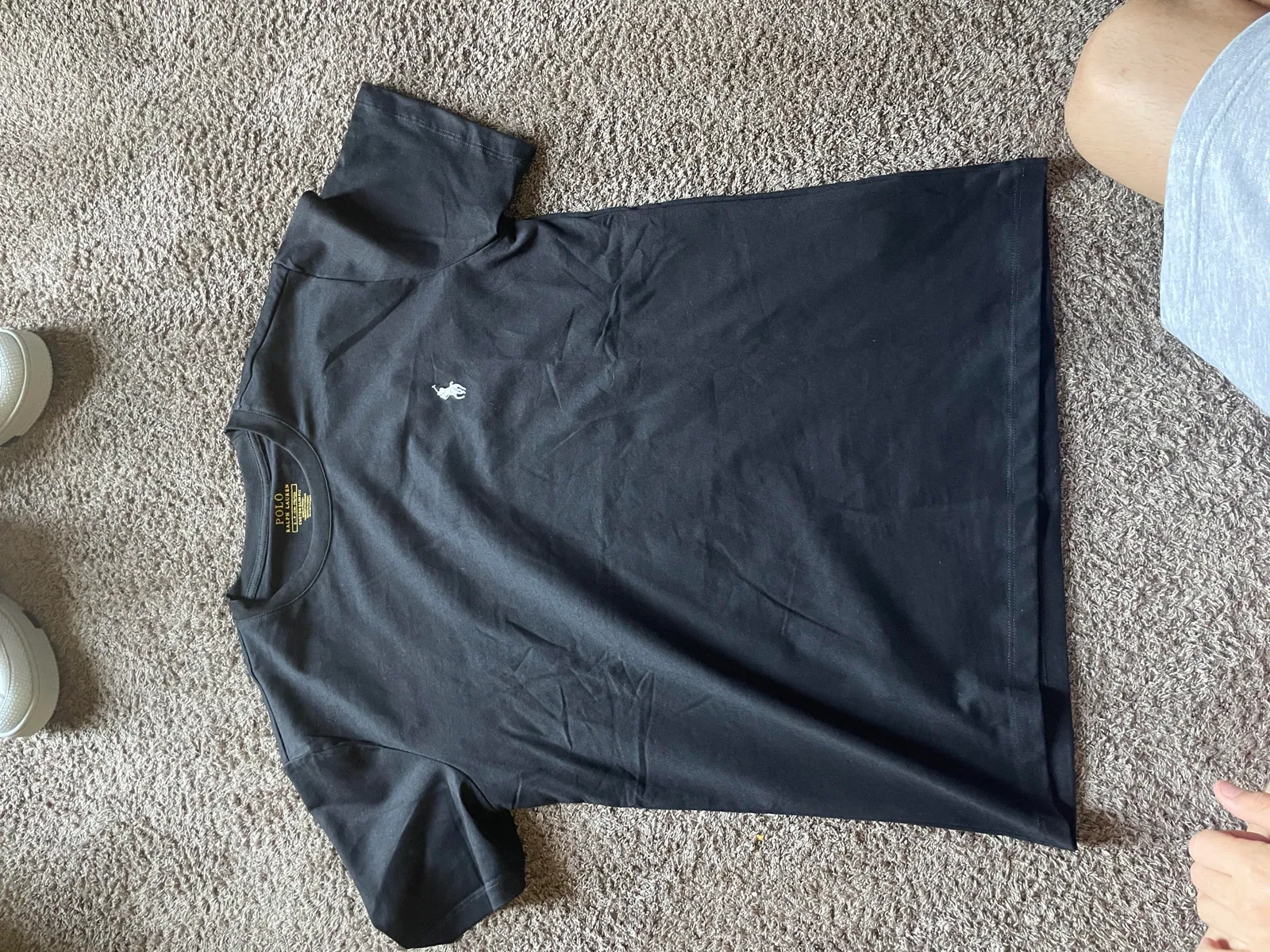 Dark short-sleeve T-shirt laid flat on carpet