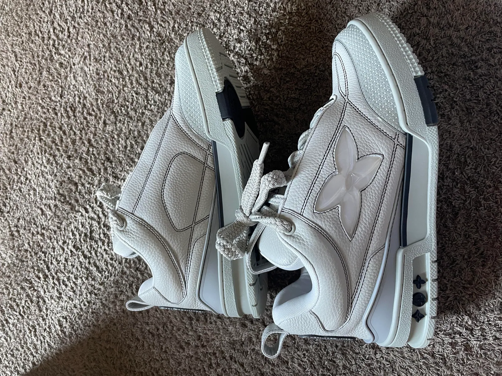 Side view of white chunky sneakers on carpet