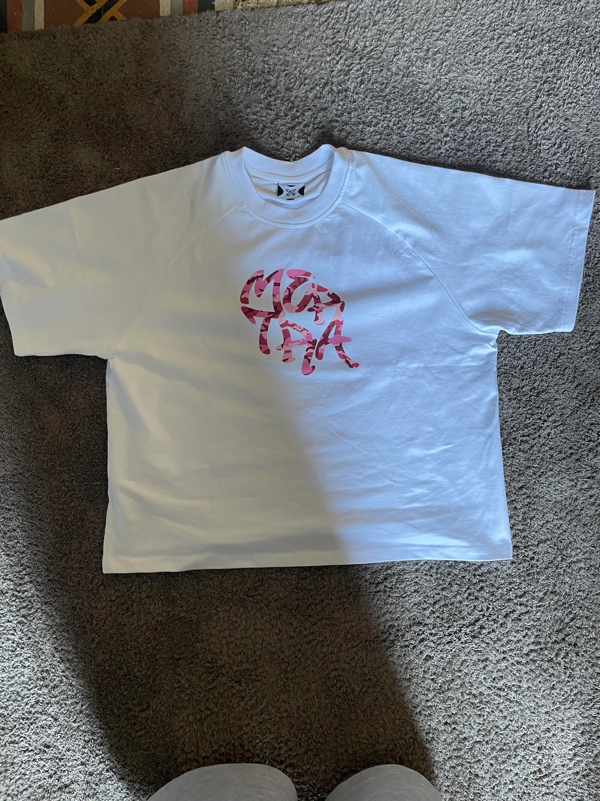 White T-shirt with a red graphic print laid flat